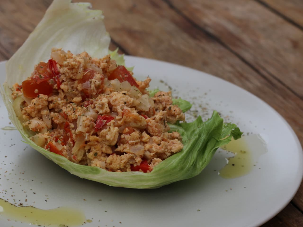 Bateau de laitue avec oeufs brouillés et oignon tomate