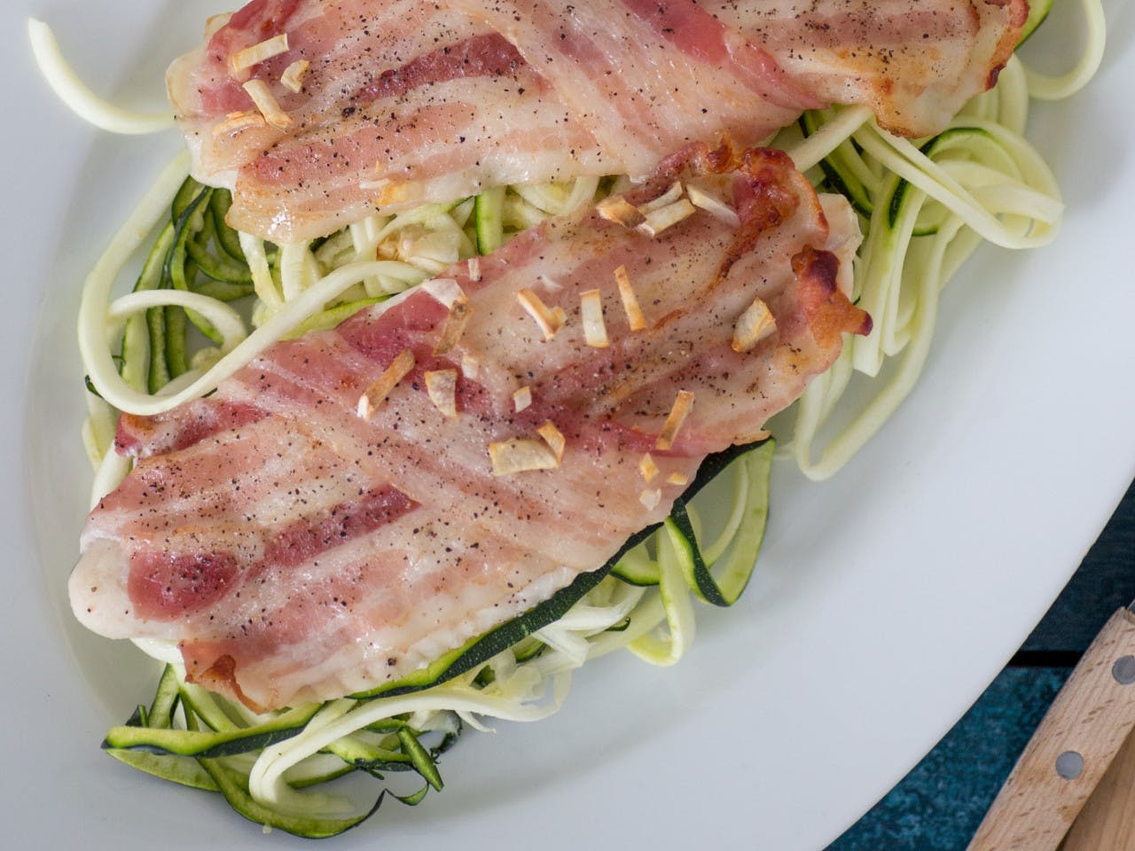 White fish with bacon on a bed of zoodles