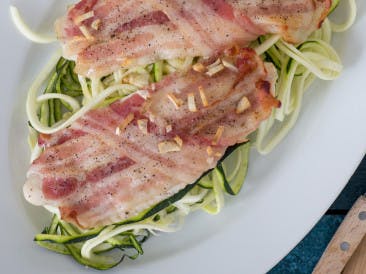 White fish with bacon on a bed of zoodles