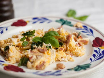 Scrambled eggs with bacon and basil
