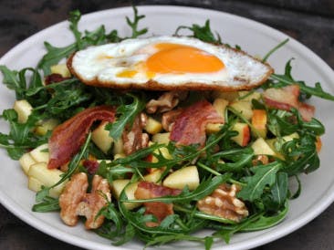 Arugula salad with bacon, egg and walnuts