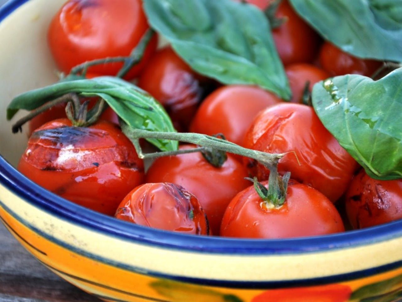 Grilled cherry tomatoes with basil leaves