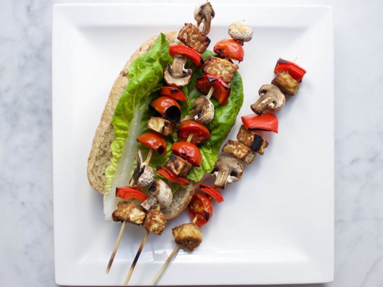 Vegan BBQ tempeh and mushroom skewers with romaine lettuce