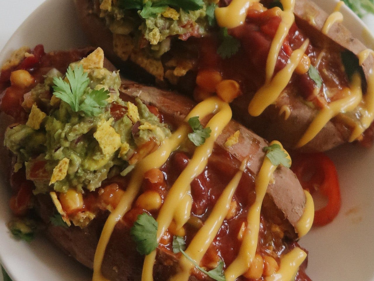 Stuffed sweet potato with Mexican salsa mix, guacamole and easy vegan cheese sauce
